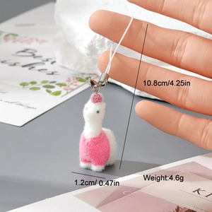 Macro shot of a tiny flocked alpaca keychain showing its soft texture and compact size