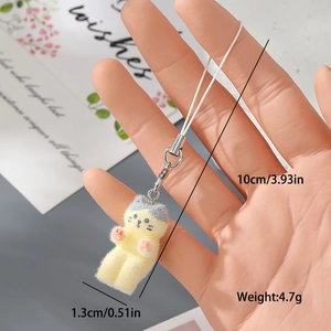 Detailansicht der gelben beflockten Katzenfigur in der Hand mit Fokus auf weiche Textur