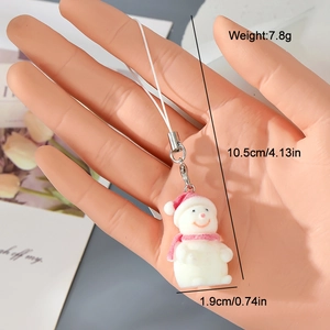 Detailed view of flocked snowman keychain with pink scarf and dimensions on model hand