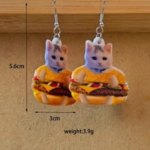 Detail view of funny acrylic earrings showing a cat in a burger with size measurements