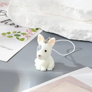 Cute white flocked resin puppy keychain with metal ring and cord on aesthetic background