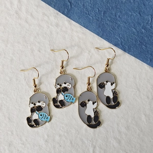 Close-up of cute sea lion earrings with enamel detail and golden stainless steel hooks