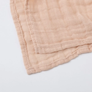 Detail shot of soft double-layer bamboo cotton gauze fabric with natural orange-pink texture