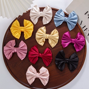 Detailed top view of 9-piece satin bow hair clip set in assorted elegant colors
