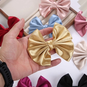 Macro shot of large satin bow hair clips in various colors with elegant silk texture