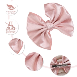 Detailed macro view of pink satin bow hair clip with eco-friendly non-fluorescent fabric