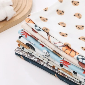 Close-up of soft cotton baby swaddle fabrics with cute bear and sports pattern prints