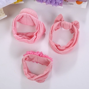 Vue détaillée d'un lot de trois bandeaux roses pour bébé avec fleurs et nœuds doux