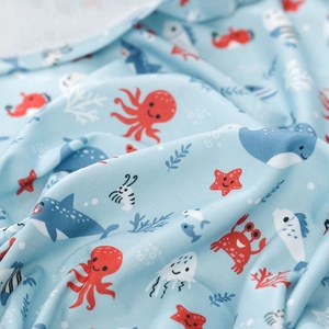 Close-up of breathable baby swaddle fabric with cartoon octopus and shark prints