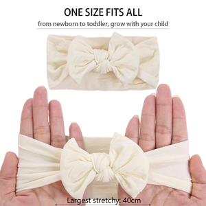 Détail du bandeau large en nylon extensible pour bébé en blanc crème, s'étirant jusqu'à 40 cm
