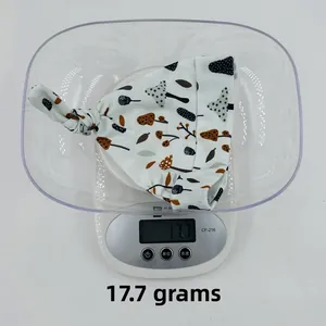 Detailed view of lightweight baby knotted hat in mushroom print showing 17.7g weight