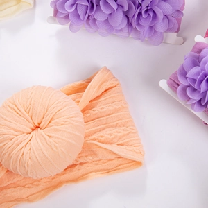 Vue détaillée d'un bandeau pour bébé avec nœud orange et texture en maille douce
