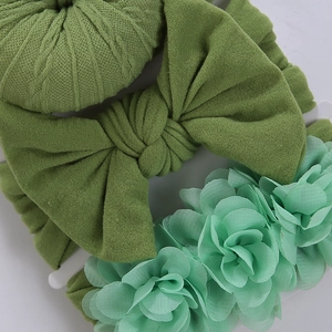 Détail d'un lot de bandeaux bébé avec nœuds en tricot et fleurs en mousseline douce