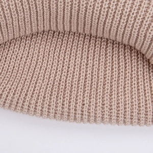 Vue macro détaillée montrant la texture douce de la maille côtelée et gaufrée de ce bonnet bébé