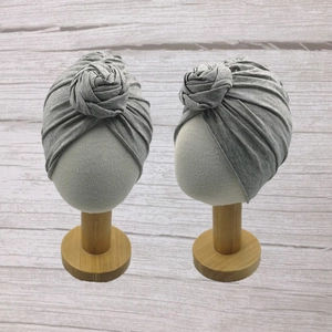 Close-up of grey cotton baby turban hats with layered rose knot detail and soft texture