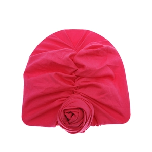 Detailed close-up of a dark pink baby turban hat with a large handmade fabric rose decor