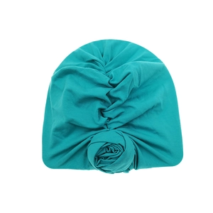 Detail of teal cotton turban hat for babies featuring a soft ribbed texture and rosette knot