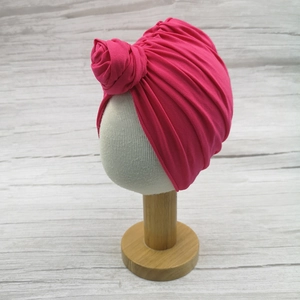 Soft rose red cotton baby turban hat with decorative flower knot on mannequin head