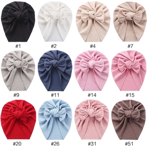 Detail view of baby bow turban hats in twelve colors with ribbed knit fabric texture