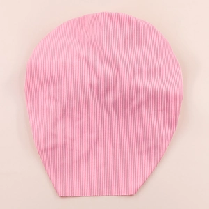 Detailed close-up of pink ribbed knit baby hat with soft elastic cotton texture
