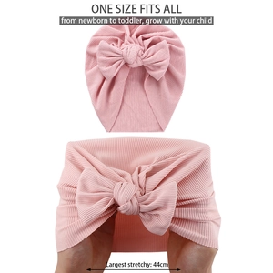 Detail showing high elasticity and ribbed knit texture of pink baby bow beanie hat