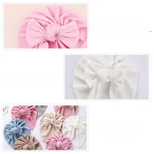 Detail of soft ribbed cotton baby beanies with handmade oversized decorative bows