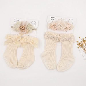 Detailed set of floral baby headband and matching bow socks for infant photography
