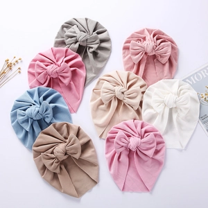 Soft ribbed cotton baby bow hats in various colors including pink, grey, and beige