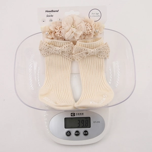 Close-up of lightweight 39.8g baby lace headband and matching knit socks gift set