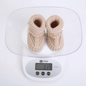 Detailed view of lightweight 31.4g knitted baby socks on a digital weight scale