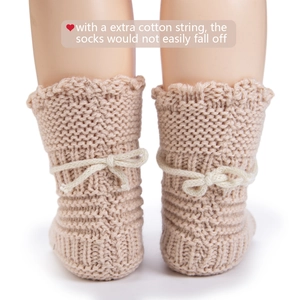 Detail view of knitted baby socks with extra cotton string to prevent slipping on legs