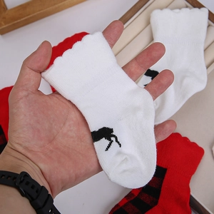 Nahaufnahme von gestrickten Babysocken mit Wellenkante und Weihnachtsmuster