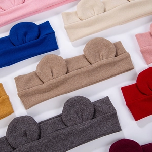 Close-up of knit baby headbands with bear ears in various colors like pink and blue