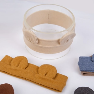 Detail of soft knitted baby headbands with cute bear ears in various warm pastel colors