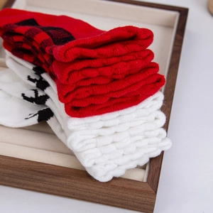 Detailansicht dicker gestrickter Babysocken mit Karomuster und Rentier-Motiven