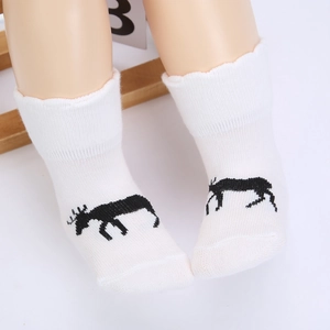 Detail von weißen Baby-Stricksocken aus Baumwolle mit schwarzem Rentier-Silhouette-Muster