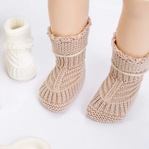 Knitted baby walking socks in beige and cream with soft yarn texture and lace-up ties