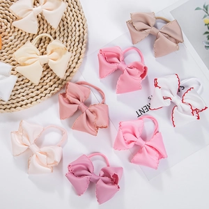 Handmade nylon headbands with embroidered grosgrain ribbon bows for babies in soft pastel colors