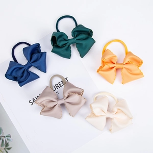 Detailed macro view of five colorful embroidered ribbon bow headbands with wavy edges