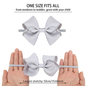Detailed macro showing high elasticity of embroidered bow headband for infants