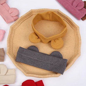 Cute infant headband with bear ears in multiple colors displayed on a brown tray