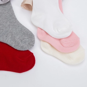 Gros plan détaillé de chaussettes bébé en coton multicolores avec rubans en satin