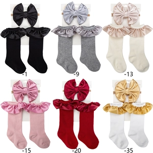 Detail view of baby headband and socks set in six colors with satin floral ruffles