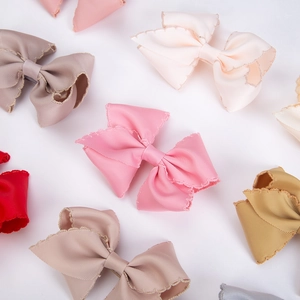 Detailed macro view of colorful ribbed fabric bow hairclips with precise zigzag edges