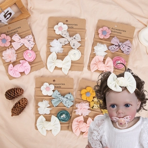 Detailed view of five-piece chiffon flower and lace bow baby headbands on kraft card