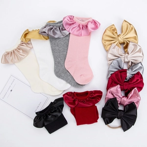 Detail of baby socks and headband set with satin ruffles and bows in multiple colors