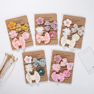 Detail view of five chiffon flower and bow headbands for babies on cardboard cards