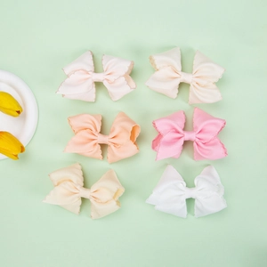 Close-up of textured grosgrain ribbon bows with elegant scalloped edges in pastel colors