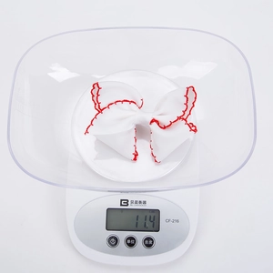 Detail shot showing a 11.4g lightweight white grosgrain ribbon hair bow on an electronic scale