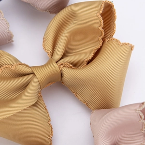 Macro view of mustard yellow grosgrain ribbon hair clip with delicate scalloped edges